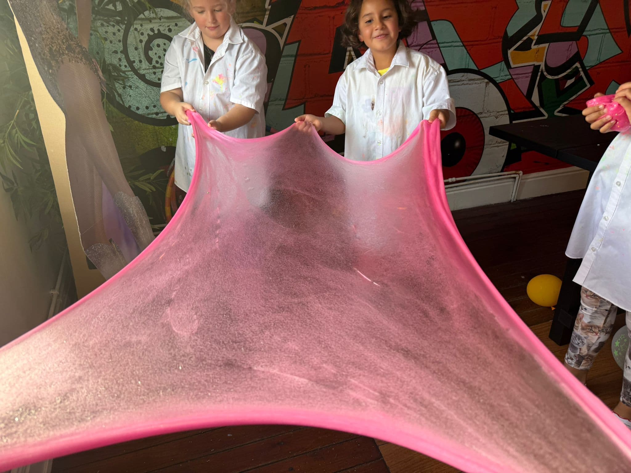 Children stretching pink slime at art-ful Worthing
