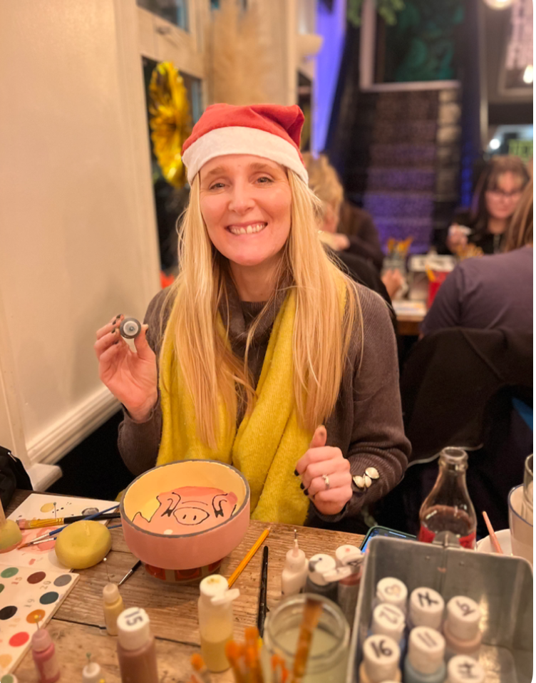 Guest enjoying a festive pottery painting party at art-ful