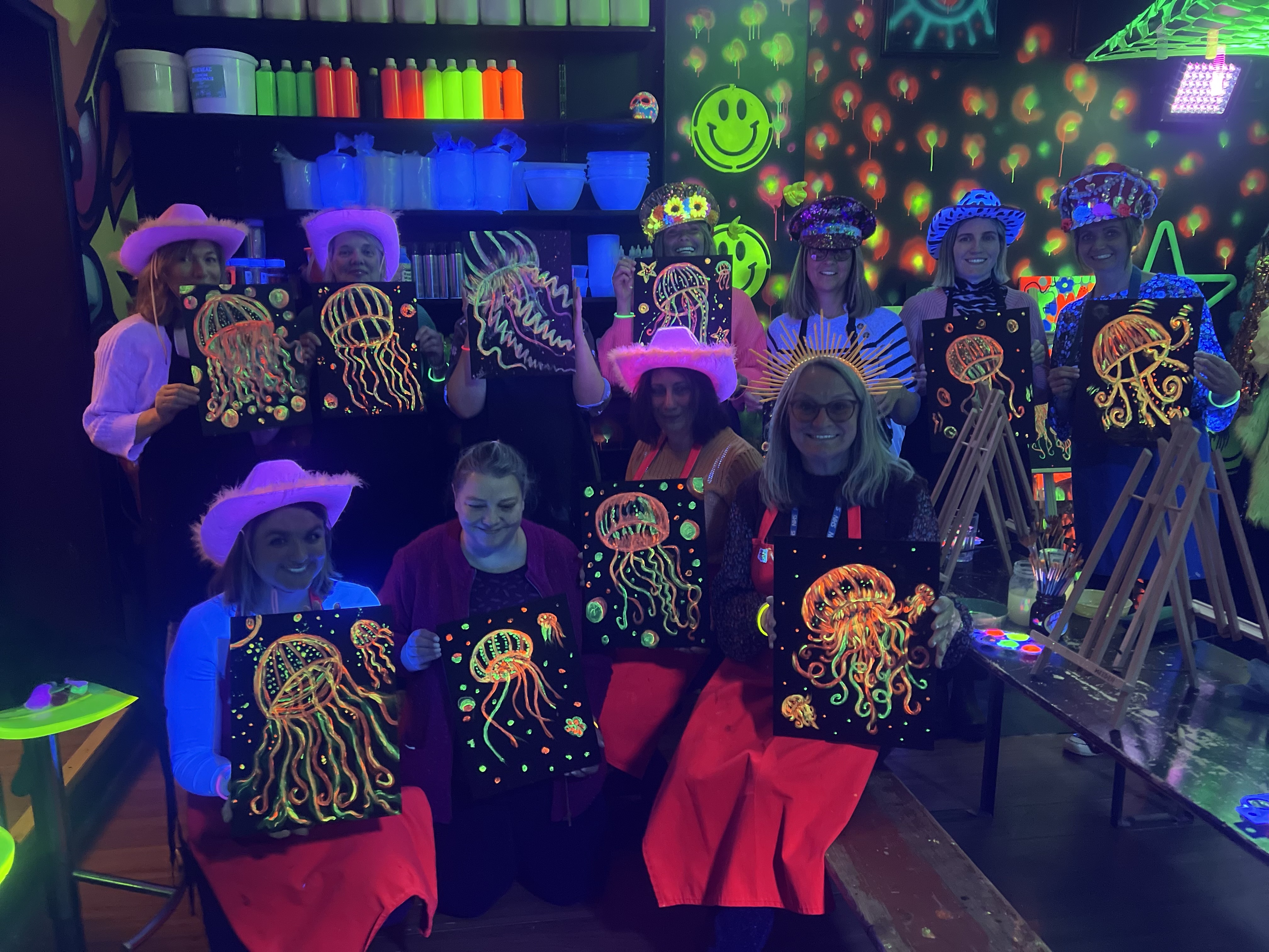 Hen party group holding neon jellyfish paintings at art-ful